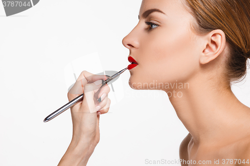 Image of Beautiful female lips with make-up and brush