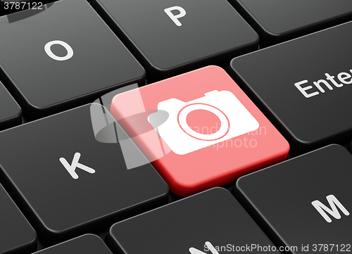 Image of Tourism concept: Photo Camera on computer keyboard background