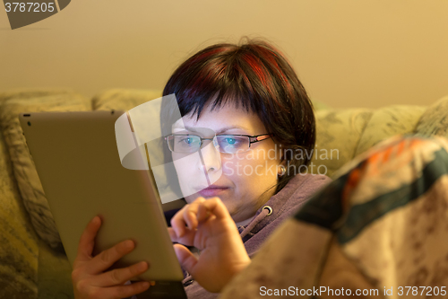 Image of woman reading news on tablet
