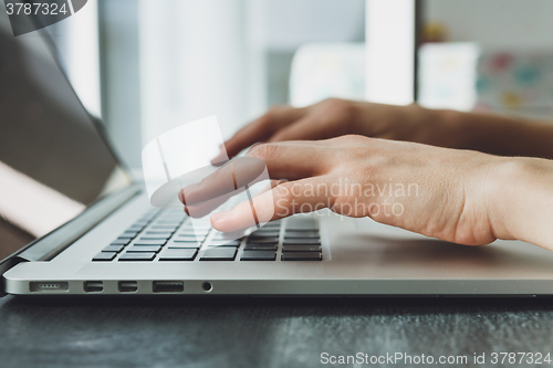 Image of woman\'s hands working on laptop computer