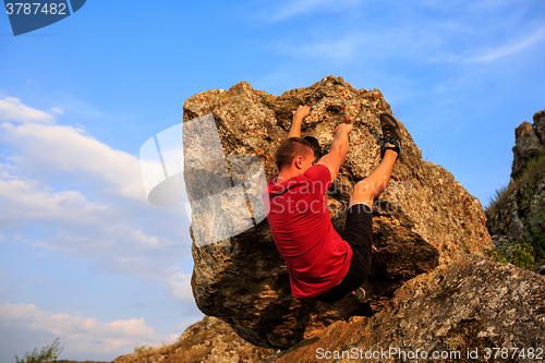 Image of Young man climbing on a wall