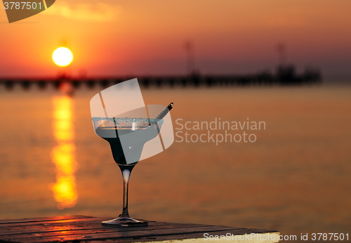 Image of Tropical cocktail overlooking a sunset ocean