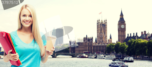 Image of smiling student girl with folders and coffee cup