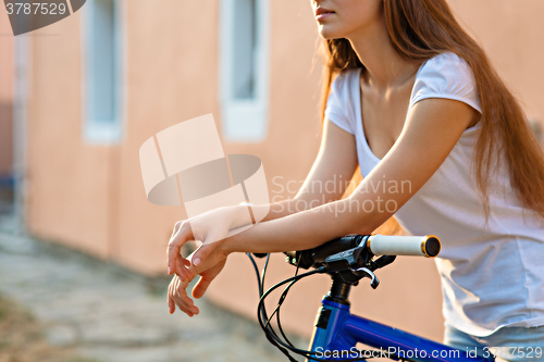 Image of The hands of young woman sitting on bicycle