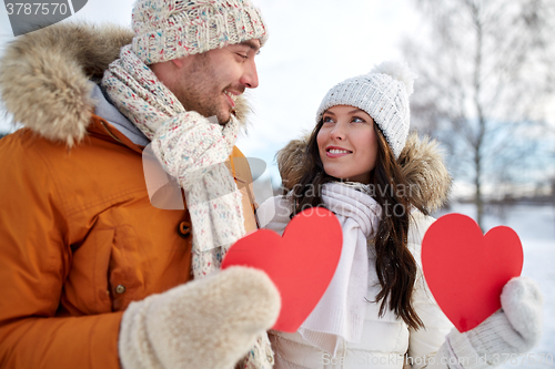 Image of happy couple with red hearts over winter landscape