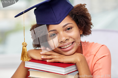 Image of happy african bachelor girl with books at home