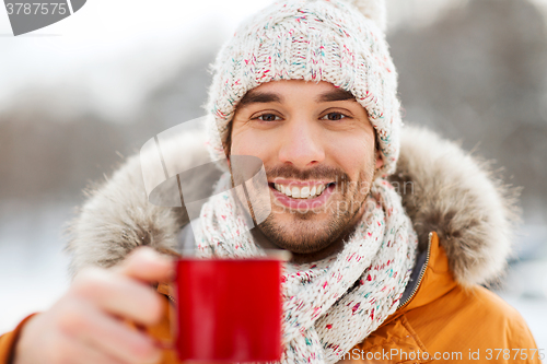 Image of happy man with tea cup outdoors in winter