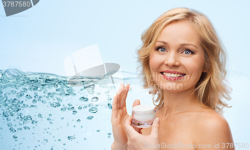 Image of happy woman applying cream to her face