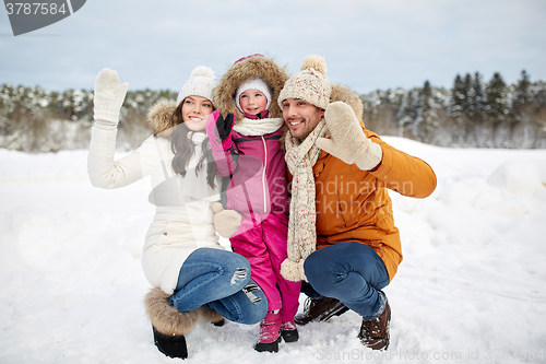 Image of happy family waving hands outdoors in winter