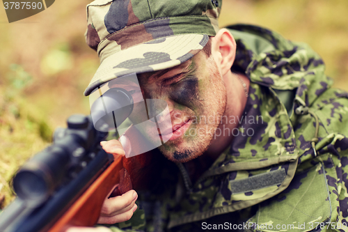 Image of soldier or hunter shooting with gun in forest