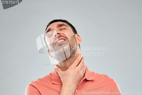 Image of man touching neck and suffering from throat pain