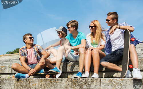 Image of happy teenage friends with longboard on street