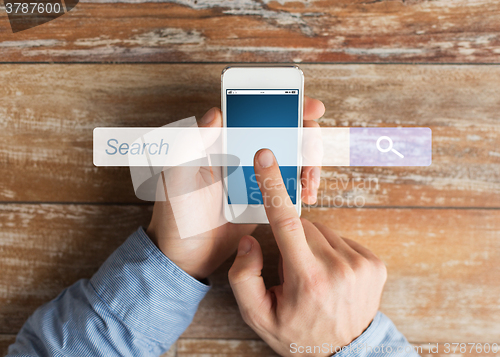 Image of close up of male hands with smartphone on table