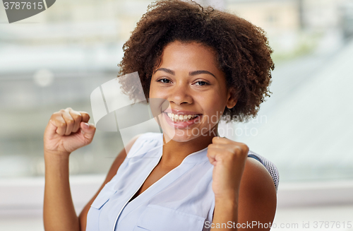 Image of happy african young woman with raised fists