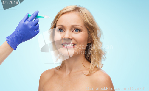 Image of happy woman face and beautician hand with syringe