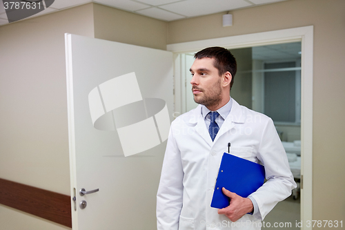 Image of doctor with clipboard at hospital corridor