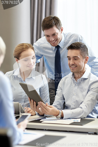 Image of smiling business people with tablet pc in office