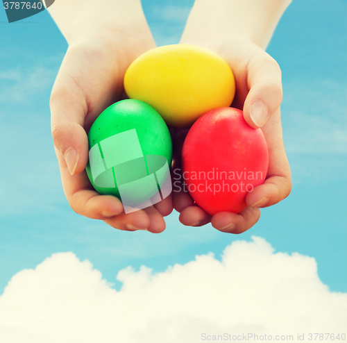 Image of close up of kid hands holding colored eggs