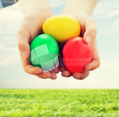 Image of close up of kid hands holding colored eggs