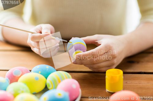 Image of close up of woman hands coloring easter eggs