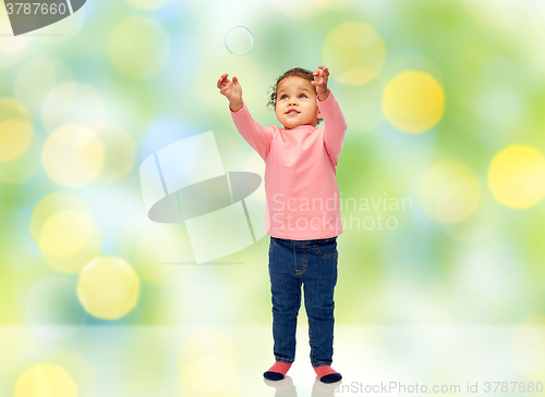 Image of little baby girl playing with soap bubble