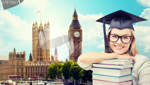 Image of student in trencher cap with books over london