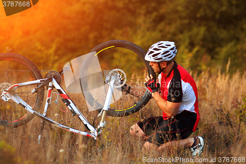 Image of man repairing his mountain bike