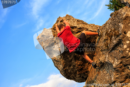 Image of Young man climbing on a wall