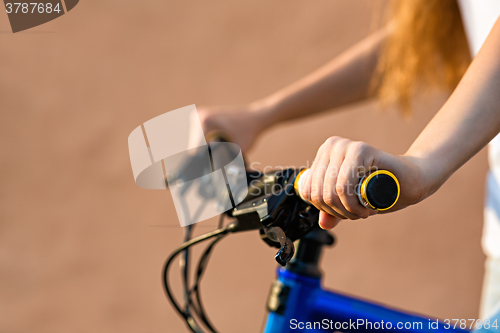 Image of The hands of young woman sitting on bicycle