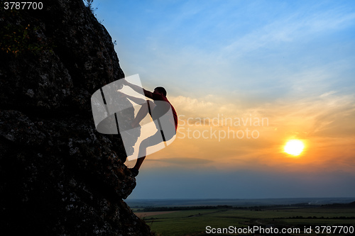 Image of Young man climbing the mountain ridge