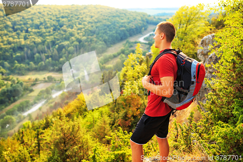 Image of Men walk along the hill with backpack