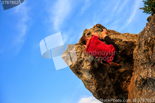 Image of Young man climbing on a wall