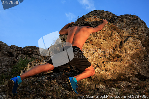 Image of Young man climbing the mountain ridge