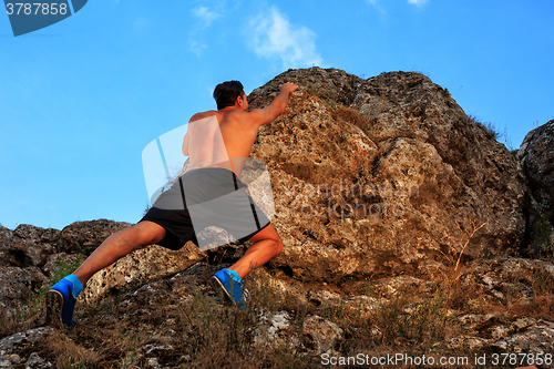 Image of Young man climbing on a wall