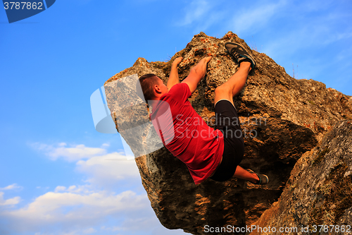 Image of Young man climbing on a wall