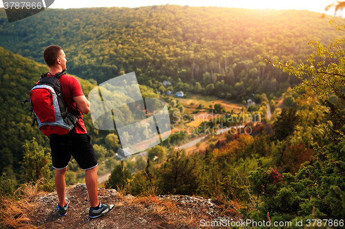 Image of Men walk along the hill with backpack