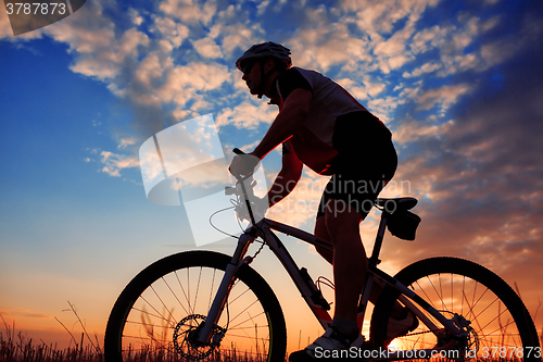 Image of mountain biker silhouette in sunrise