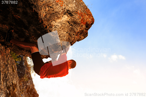 Image of Young man climbing on a wall