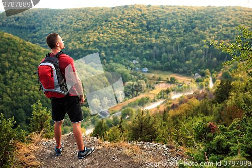 Image of Men walk along the hill with backpack