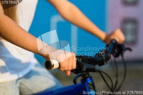 Image of The hands of young woman sitting on bicycle