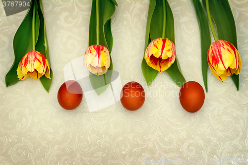 Image of Three Easter eggs and tulips.