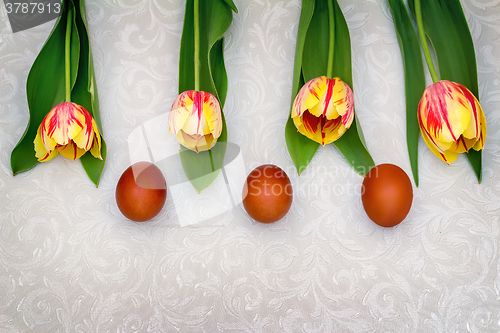 Image of Three Easter eggs and tulips.