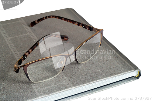 Image of Glasses and notebook on a white background.