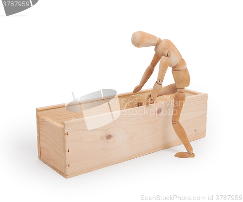 Image of Wood figure mannequin stepping in a wooden box