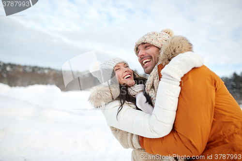 Image of happy couple hugging outdoors in winter