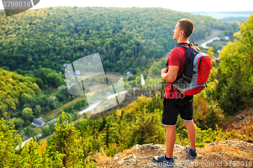 Image of Men walk along the hill with backpack