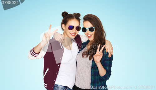 Image of smiling teenage girls in sunglasses showing peace