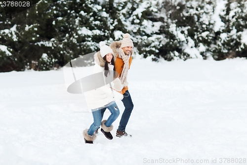 Image of happy couple running over winter background