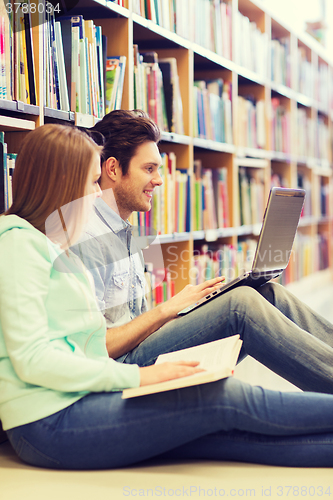 Image of happy students with laptop in library