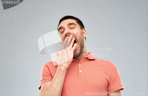 Image of yawning man over gray background